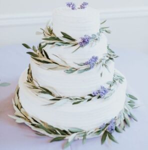 A four-tiered white cake with leaves