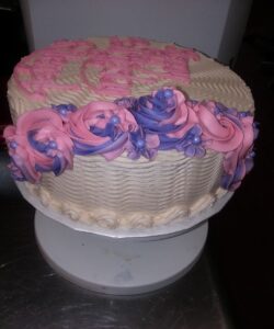 A cake with purple and pink frosting