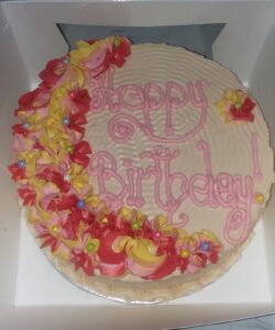 A birthday cake with pink and yellow décor